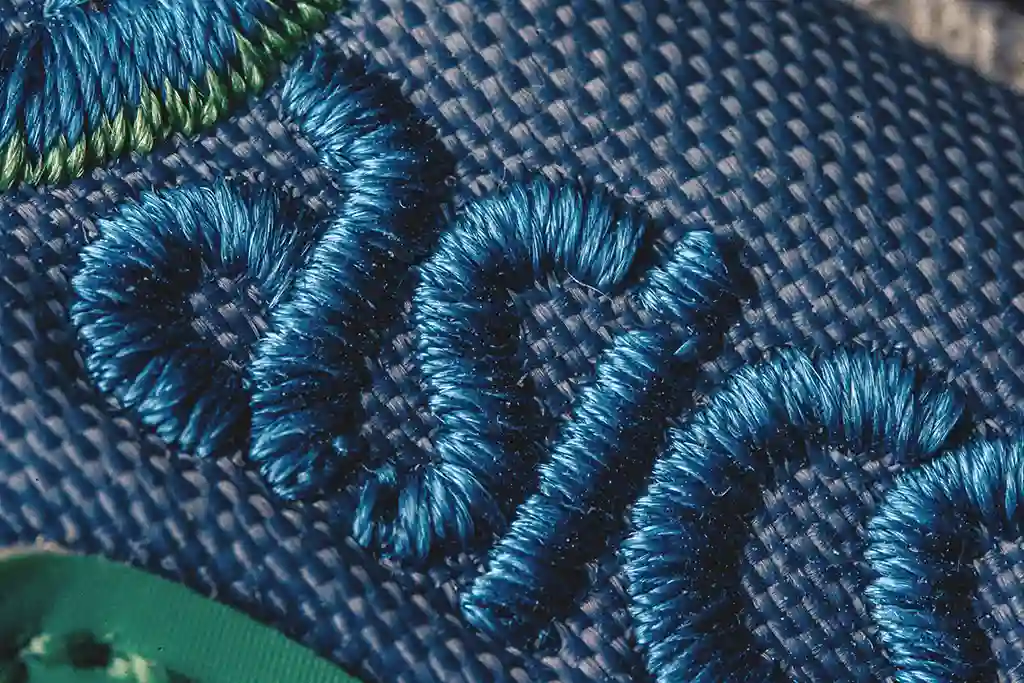 โลโก้ asics แบบลายปักลงบนหนัง