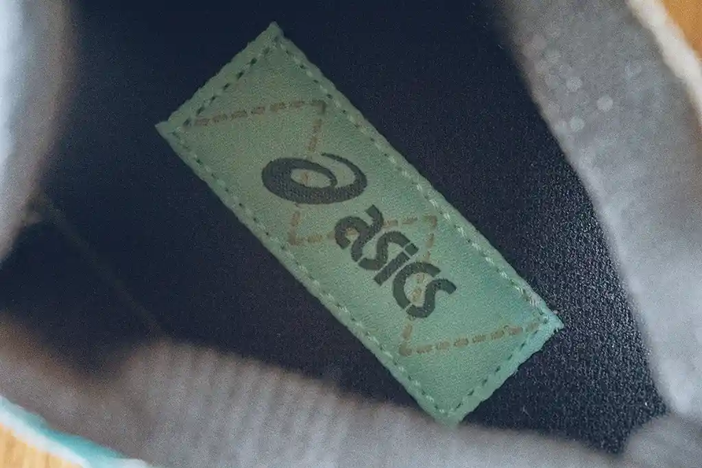 สัญลักษณ์ Logo : ASICS สกรีนบนแผ่นผ้าแล้วปักลงอีกที